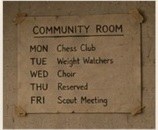 A handwritten weekly schedule taped to the community-room wall.