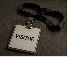 A visitor badge attached to a black lanyard